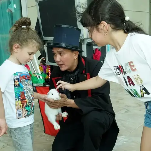 Kids express love with a rabbit that a magician discovered during their party magic show.